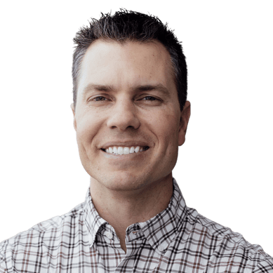 A man with a plaid shirt is smiling.